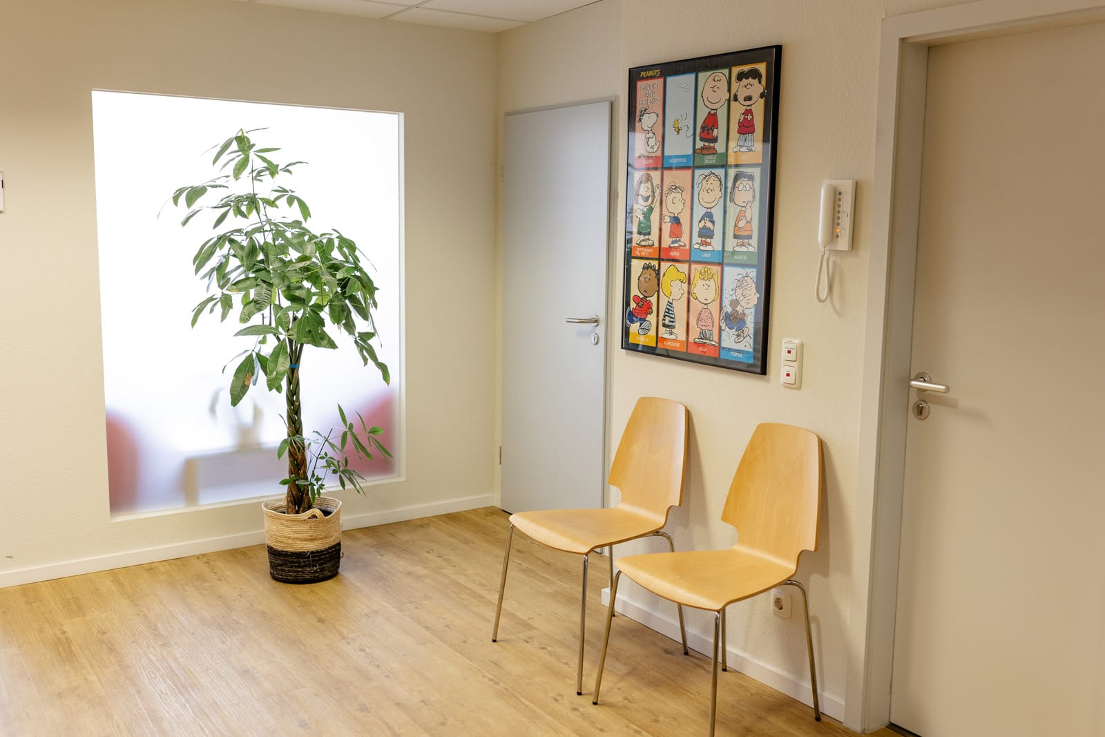 Heller, freundlicher Eingangsbereich mit einer Pflanze und zwei Stühlen